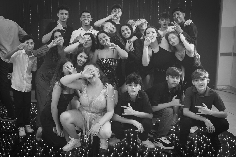 Entrada dos 15 casais: O grupo de amigos com looks casuais pulando e celebrando a energia da juventude.