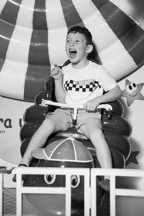 Movimento e emoção em um registro atemporal. A fotografia em preto e branco foca na expressão e na ação, criando uma memória poderosa da diversão do João.