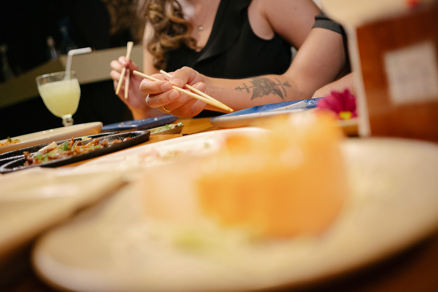 Detalhe espontâneo de Tainara e Juliano jantando no Hioki Sushi em São José dos Campos. Ensaio pré-wedding lifestyle em SJC. Como fotógrafo de casamento no Vale do Paraíba, registro momentos autênticos e afetivos do casal em seus locais favoritos.