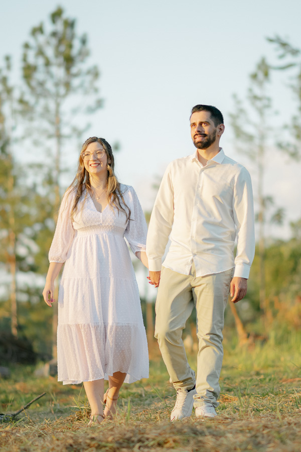 Tainara e Juliano caminhando em ensaio pré-wedding em SJC. Fotógrafo de casamento em São José dos Campos e Vale do Paraíba registrando conexão e leveza na natureza. Foto de casal externa com estilo lifestyle e luz do entardecer. Inspire-se!