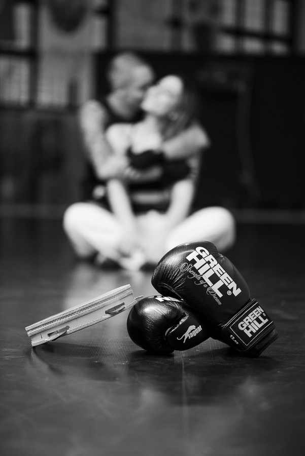 Detalhe sensível do ensaio pré-casamento de Luidgi e Aline: luvas de kickboxing e pandeiro de capoeira em foco. Fotografia de noivado em P&B que une amor e esporte. Registro profissional e criativo para inspirar o seu álbum de casamento único.