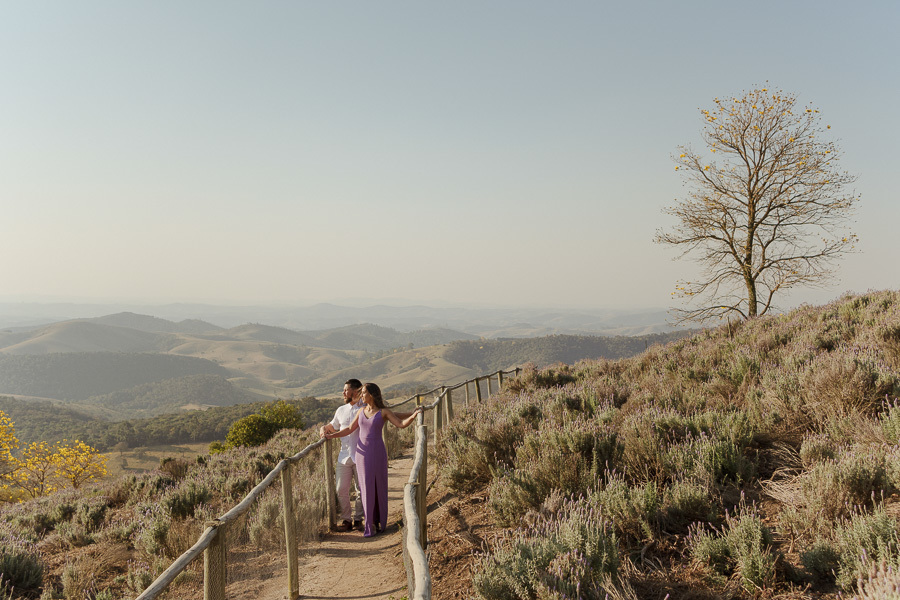 Matthaus e Rebeca admiram a vista da Serra da Mantiqueira no Lavandário de Cunha. Ensaio pré-casamento romântico com horizonte infinito e natureza exuberante. Registro profissional que encerra com perfeição este segundo capítulo.