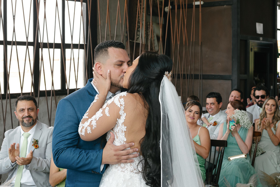 Os noivos Letícia e Juliano se beijam apaixonadamente após o 