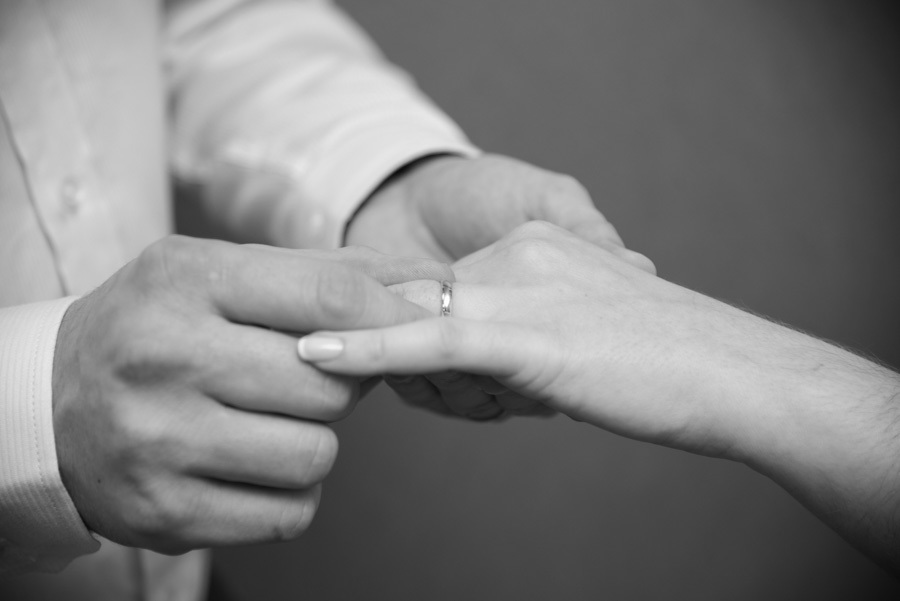 As mãos que agora carregam as alianças e que logo embalarão um bebê. Um detalhe que simboliza a união do casal e o futuro da família. A essência da fotografia de casamento.