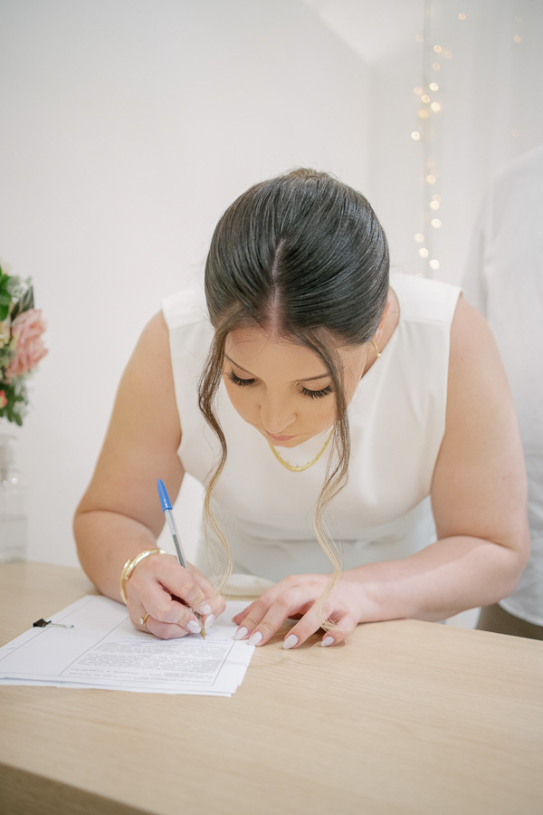 Detalhes preciosos: o buquê de noiva e as alianças, símbolos de união e amor eterno. Fotografia artística de casamento civil em São José dos Campos. Alboom.