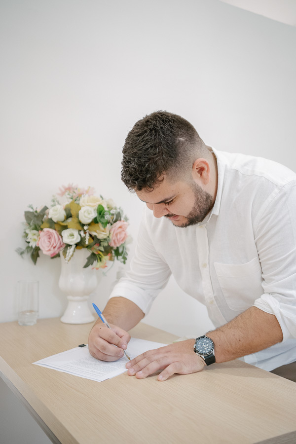 A oficialização do matrimônio: noivos assinando os documentos no cartório de registro civil. Momento solene e importante do casamento. Fotógrafo de casamento civil em Jacareí.