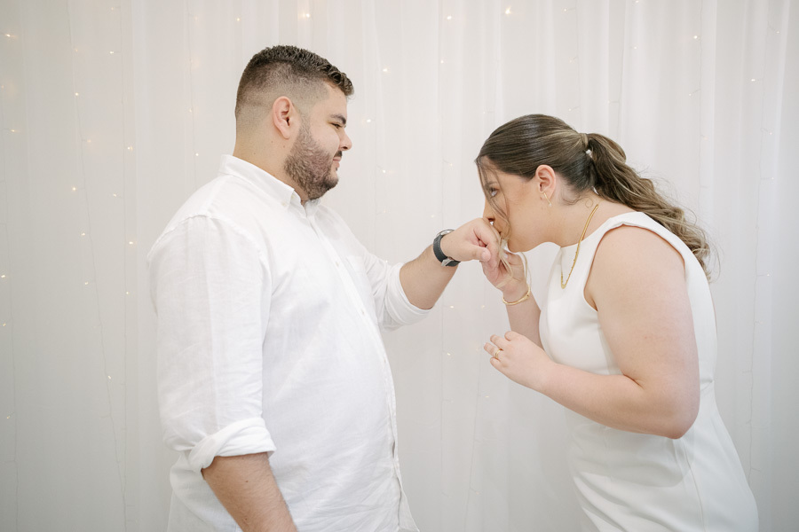 Cavalheirismo e amor: Noivo beijando a mão da noiva. Detalhe apaixonado do casamento civil de Giovanna e Guilherme.