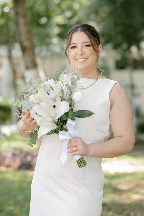 A beleza da noiva Giovanna: destaque para o buquê de flores brancas e o look elegante para casamento civil. Inspiração para noivas.