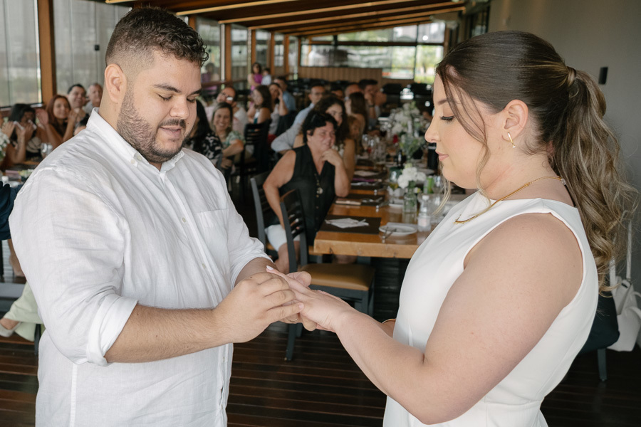 Casal em harmonia: Noivos sorrindo no jardim, com destaque para o buquê de lírios. Fotografia de casamento em São José dos Campos e região.