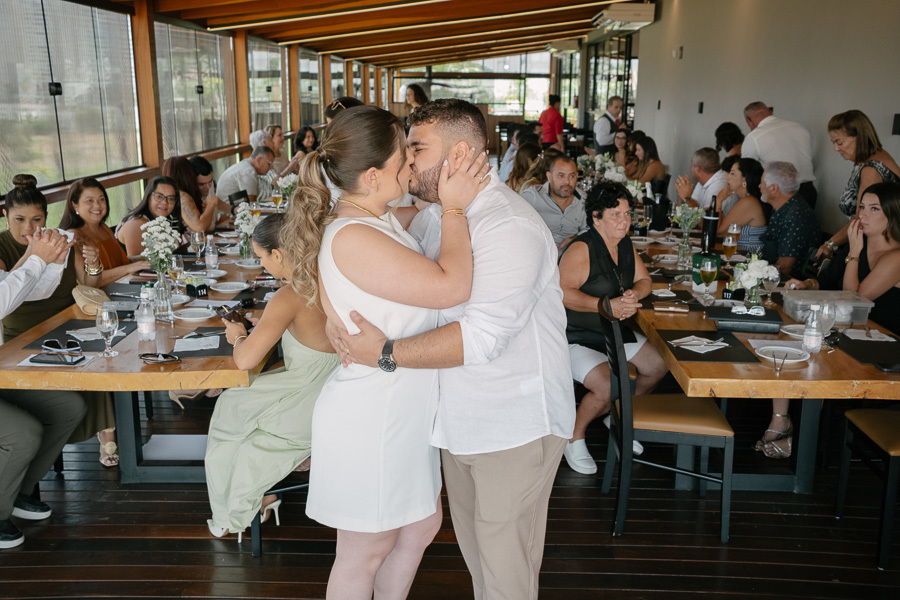 O beijo apaixonado: Giovanna e Guilherme celebram o amor no meio do salão. Fotografia vibrante de casamento no Boigalê.