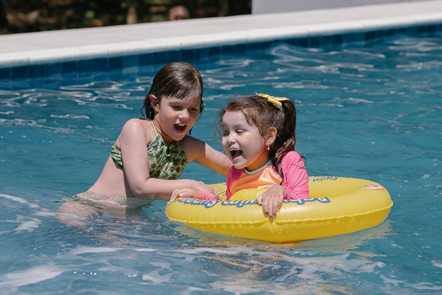 Brincadeiras e carinho até debaixo d'água. Acompanhar a família em todos os momentos da festa garante as memórias mais genuínas e completas. Um diferencial na fotografia de aniversário.