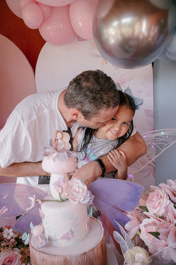 O abraço que encerra a celebração com chave de ouro. Aquele momento de puro afeto e gratidão entre pai e filha. É a captura de sentimentos assim que torna a fotografia de festa tão especial.
