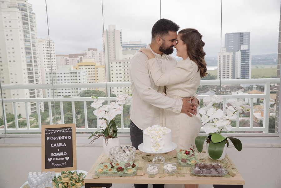 Detalhes da recepção em casa. A mesa do bolo, simples e elegante, reflete a personalidade do casal. Como fotógrafo, valorizo cada detalhe que compõe a história.