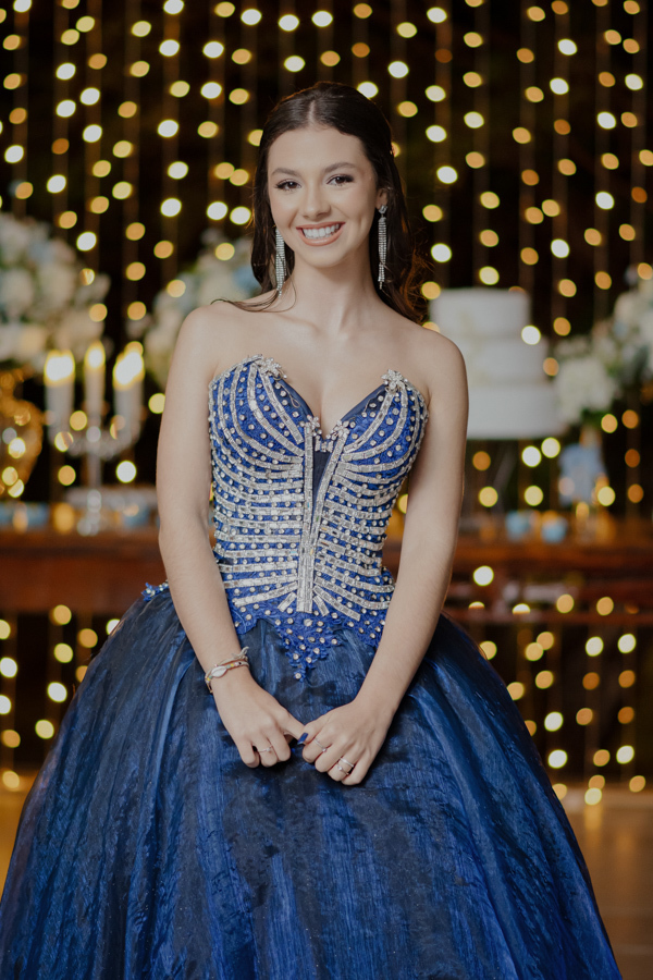 Detalhes que encantam. O foco no espartilho bordado do vestido azul, mostrando a riqueza e o luxo do traje escolhido para celebrar os 15 anos em grande estilo.