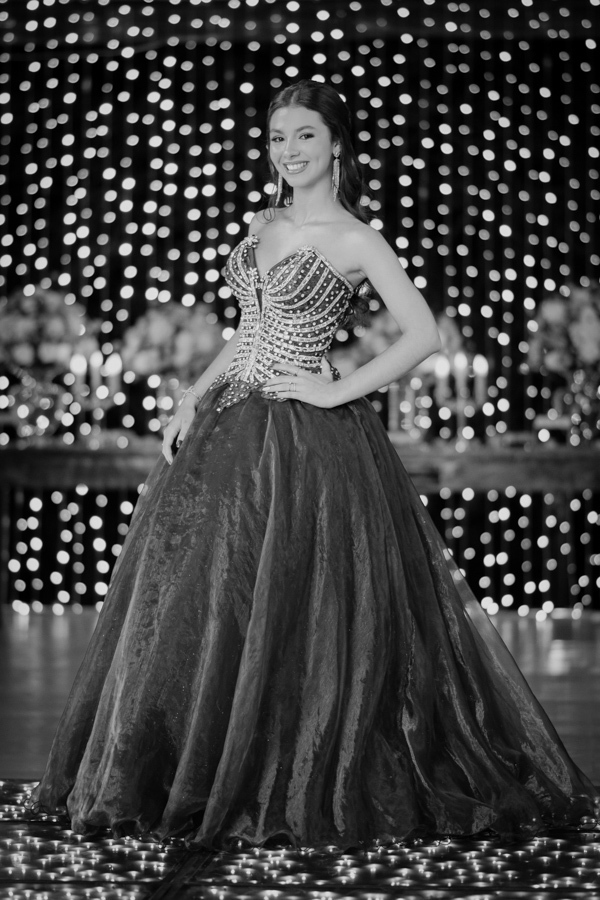 Elegância atemporal em preto e branco. Um retrato clássico que destaca a silhueta do vestido de valsa e a postura graciosa da debutante em sua noite de sonho.