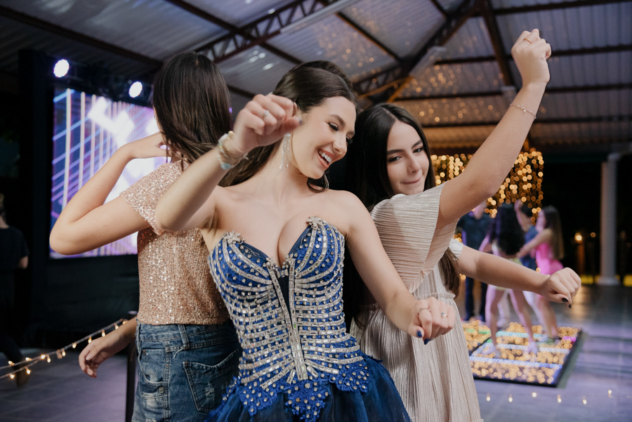 oreografia e descontração! A debutante se diverte fazendo poses com as amigas na pista de dança, com o telão de LED criando o cenário perfeito para a balada.
