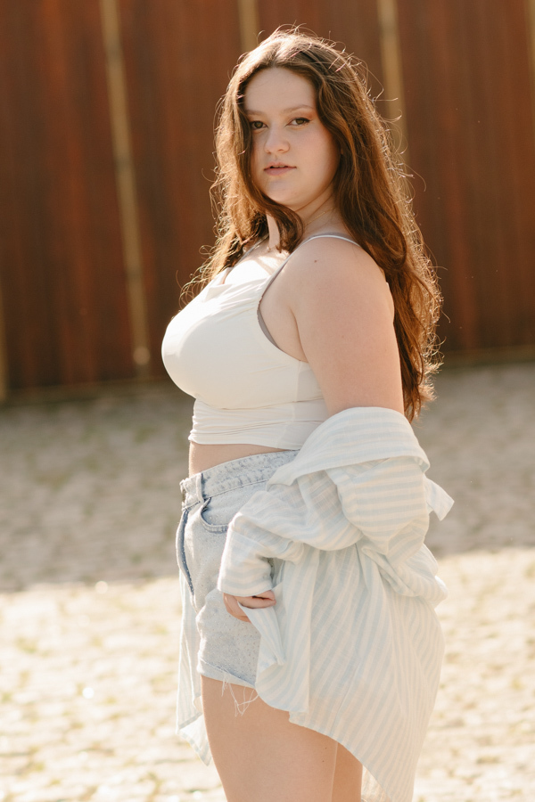 Golden Hour: Retrato da Kiara iluminada pelo sol poente. A beleza da luz dourada no ensaio de 15 anos ao ar livre.