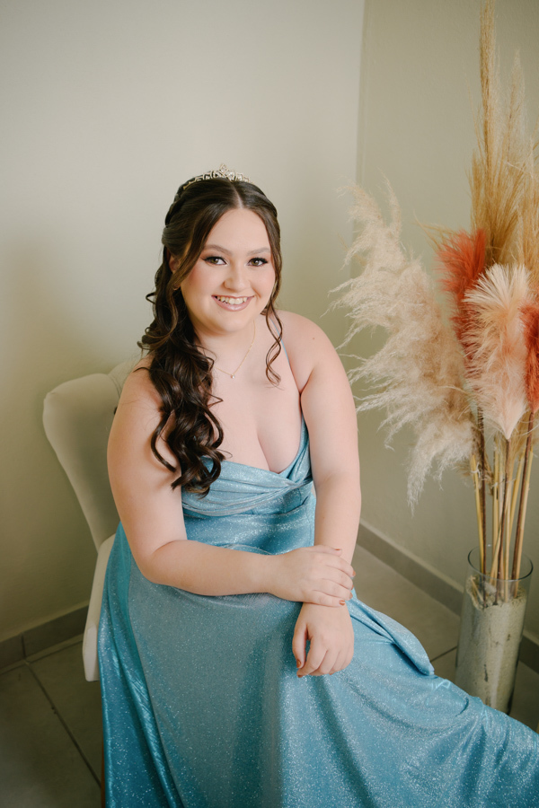 Elegância e sofisticação! A debutante posa com seu vestido azul, exibindo toda sua beleza e postura de princesa. Ensaio de 15 anos em Jacareí, preparativos para uma noite inesquecível no Espaço Lisbon.