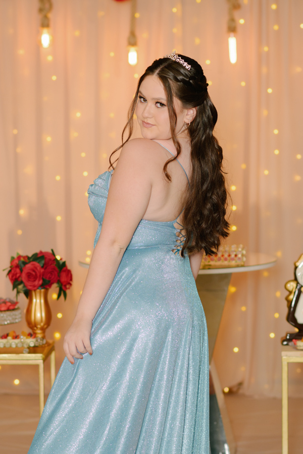 Charme no olhar. Pose de ombro destacando o penteado, o vestido azul e a atmosfera mágica da festa de 15 anos no Espaço Lisbon em Jacareí.