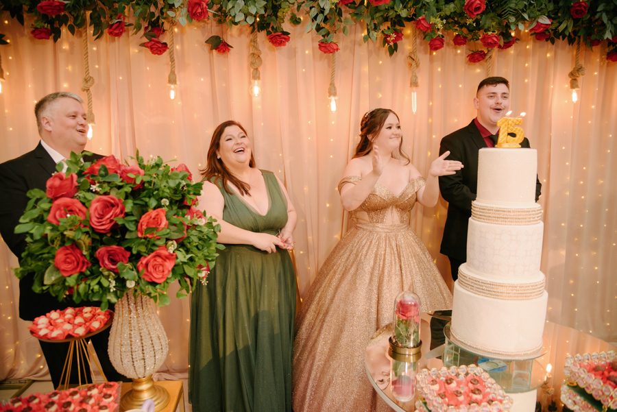 Retrato de família na mesa do bolo temática. para o parabéns Pai, mãe , irmão e debutante celebram os 15 anos com decoração de A Bela e a Fera no Espaço Lisbon em Jacareí.