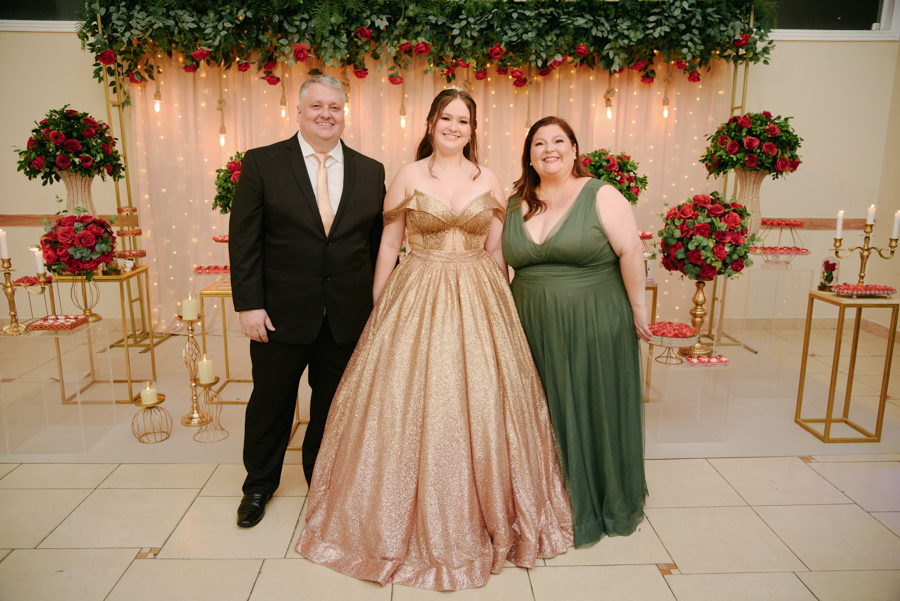 Retrato de família na mesa do bolo temática. Pai, mãe e debutante celebram os 15 anos com decoração de A Bela e a Fera no Espaço Lisbon em Jacareí.