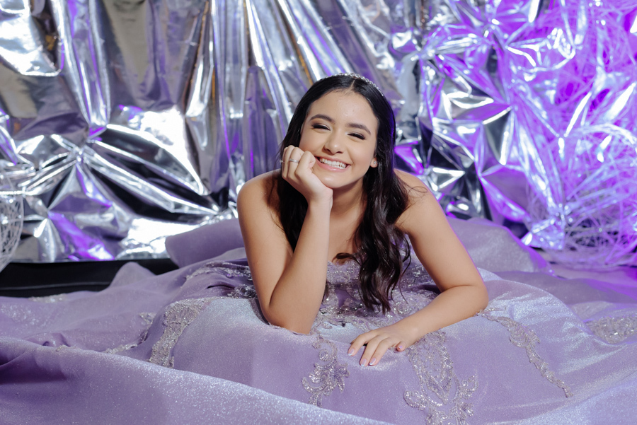 Fotografia de 15 anos da atriz Juju Salini no Espaço Le Six, Jacareí. Registros profissionais do making of com brinde, ensaio com vestido lilás de gala e festa temática cinema. O melhor fotógrafo de debutantes para eternizar seu sonho com estilo e emoção.