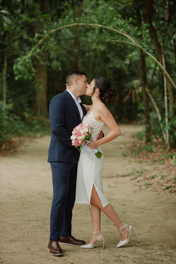 Fotógrafo de casamento em São José dos Campos registra beijo dos noivos Karla e Diego em plano aberto no Parque da Cidade. Ensaio pós-casamento civil com cenário natural e arborizado, destacando a elegância e o amor do casal na região de SJC.