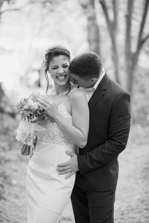 Foto preto e branco de noivos em momento de descontração no Parque da Cidade em SJC. Fotógrafo de casamento em São José dos Campos captura o sorriso espontâneo da noiva Karla e o carinho do noivo Diego após o casamento civil em Jacareí.