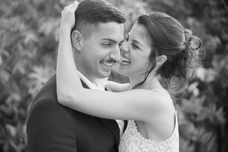 Foto preto e branco de noivos rindo abraçados durante recepção em chácara. Fotógrafo de casamento em Jacareí captura a alegria espontânea de Karla e Diego após o casamento civil, destacando a emoção e o clima festivo da celebração em família.