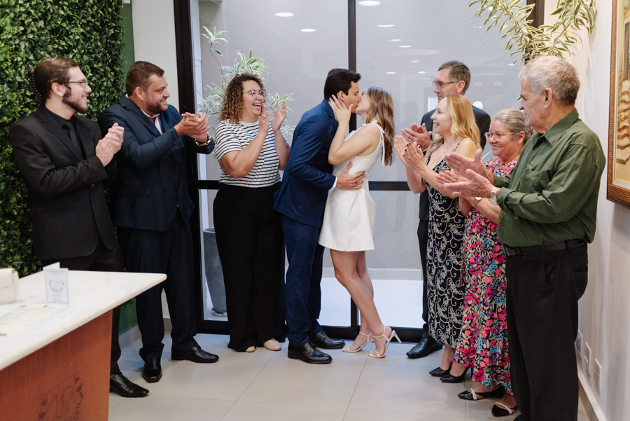 Casal de noivos se beija sob aplausos de familiares após o 