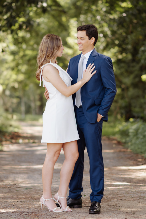 Ensaio de casal no Parque da Cidade em São José dos Campos. Ana Luiza e Felipe Antônio trocam olhares carinhosos em meio à natureza. Fotografia de casamento civil em SJC que destaca a cumplicidade dos noivos e a beleza natural do Parque Roberto Burle Marx