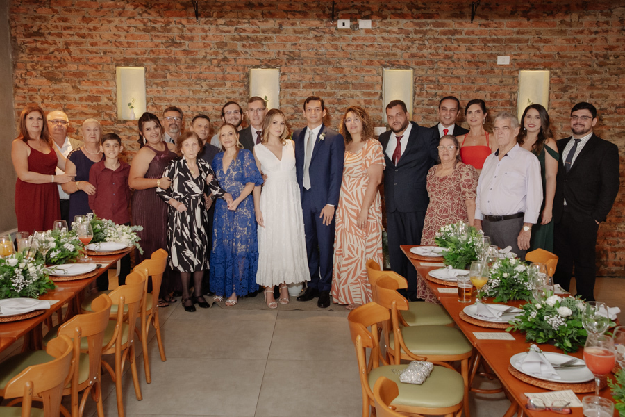 Foto oficial de Ana Luiza e Felipe Antônio com seus convidados e familiares no restaurante Auá Gastronomia. Registro de recepção de casamento civil em São José dos Campos, destacando a união das famílias em um ambiente acolhedor e elegante em SJC.