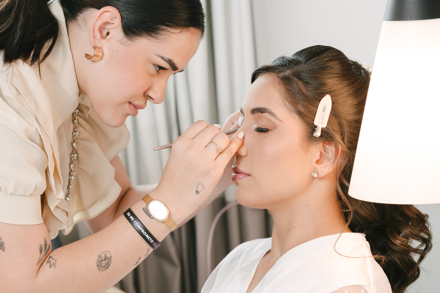 Fotografia de casamento em Jacareí: making of da noiva Rebeca. Close-up detalhado da maquiadora aplicando sombra nos olhos da noiva, destacando a preparação delicada, a maquiagem iluminada e a expectativa para a cerimônia na Chácara Lopes.