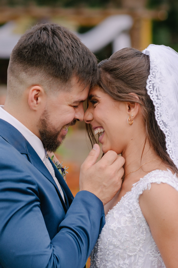 Fotografia de casamento em Jacareí: close espontâneo de Matthaus e Rebeca na Chácara Lopes. Os noivos sorriem alegremente com as testas e narizes encostados, em um momento de cumplicidade e felicidade ao ar livre após a cerimônia no entardecer.