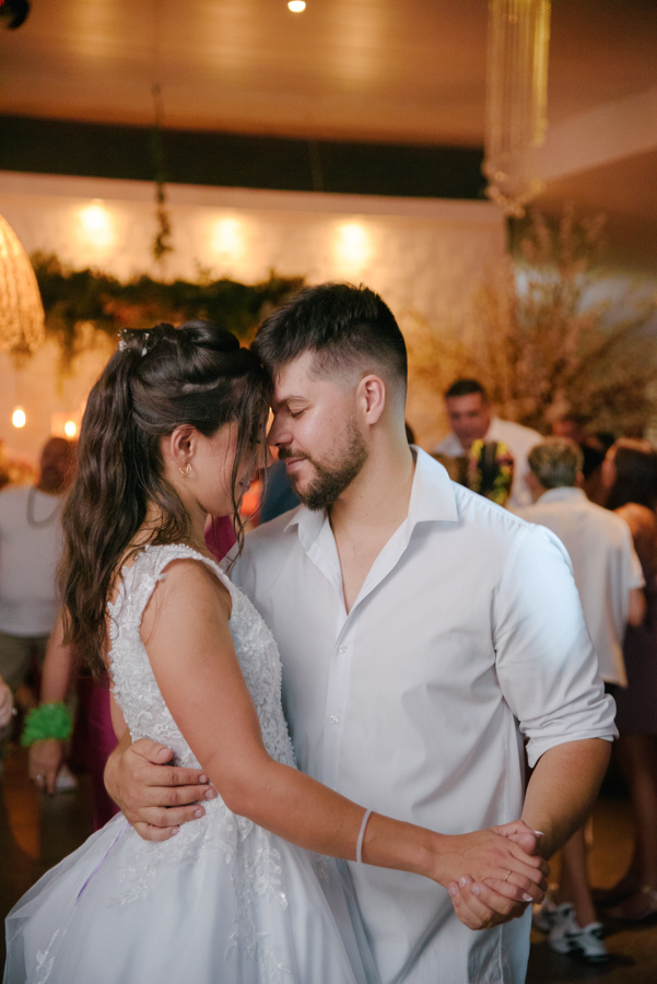 Fotografia de casamento em Jacareí: Matthaus e Rebeca em uma dança lenta e romântica na festa na Chácara Lopes. Os noivos estão com as testas encostadas e olhos fechados, em um momento de entrega e carinho sob a iluminação acolhedora da recepção.