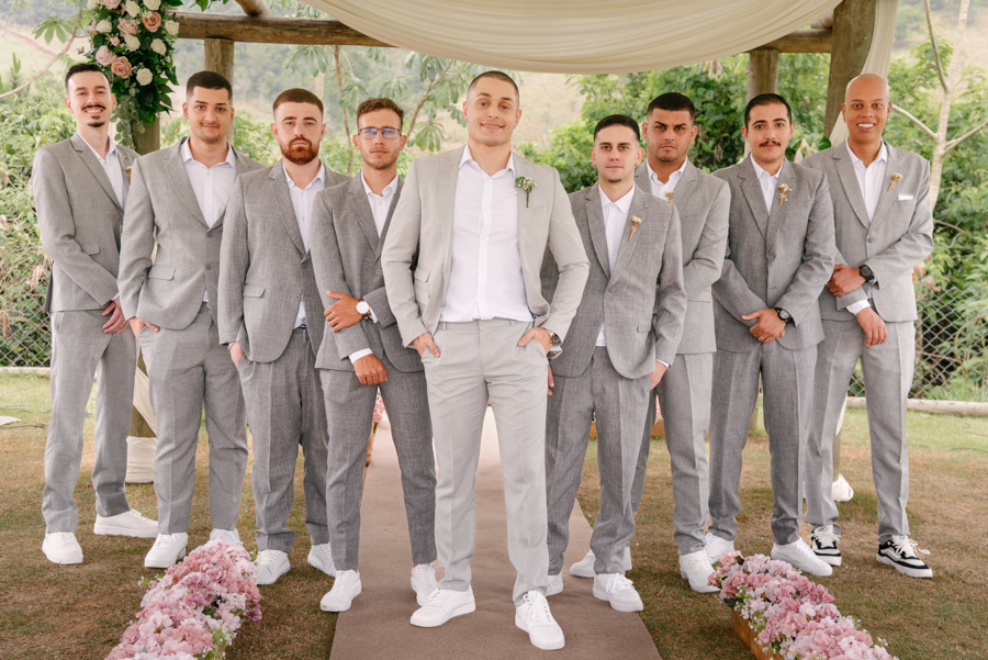 Noivo Luidgi posando com seus padrinhos, todos vestidos com ternos cinza e tênis brancos, na Chácara Mariah. Fotografia de casamento em Jacareí destacando o estilo moderno e a união do grupo. Registro profissional por fotógrafo de casamento em Jacareí.