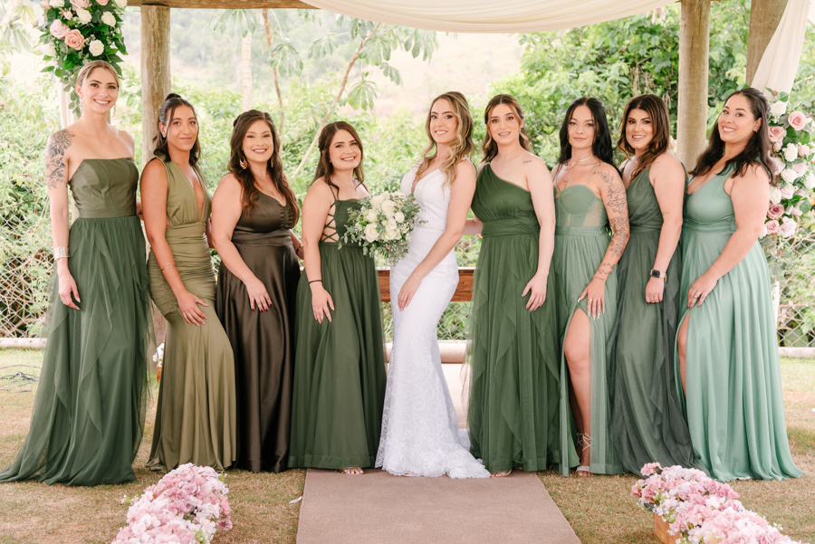 Noiva Aline posando com suas madrinhas, vestidas em tons de verde, na Chácara Mariah em Jacareí. Fotografia de casamento ao ar livre destacando a união e elegância das madrinhas. Registro profissional realizado por fotógrafo de casamento em Jacareí.