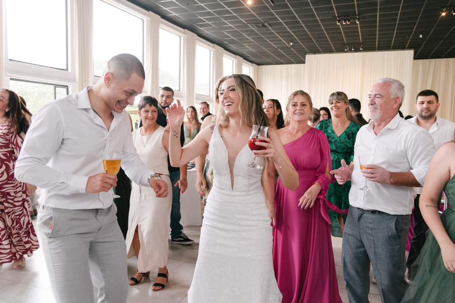 Noivos Aline e Luidgi dançam e brindam com convidados durante a festa na Chácara Mariah, em Jacareí. Fotografia de casamento capturando a alegria na pista de dança e momentos espontâneos da recepção. Registro por fotógrafo de casamento em Jacareí.