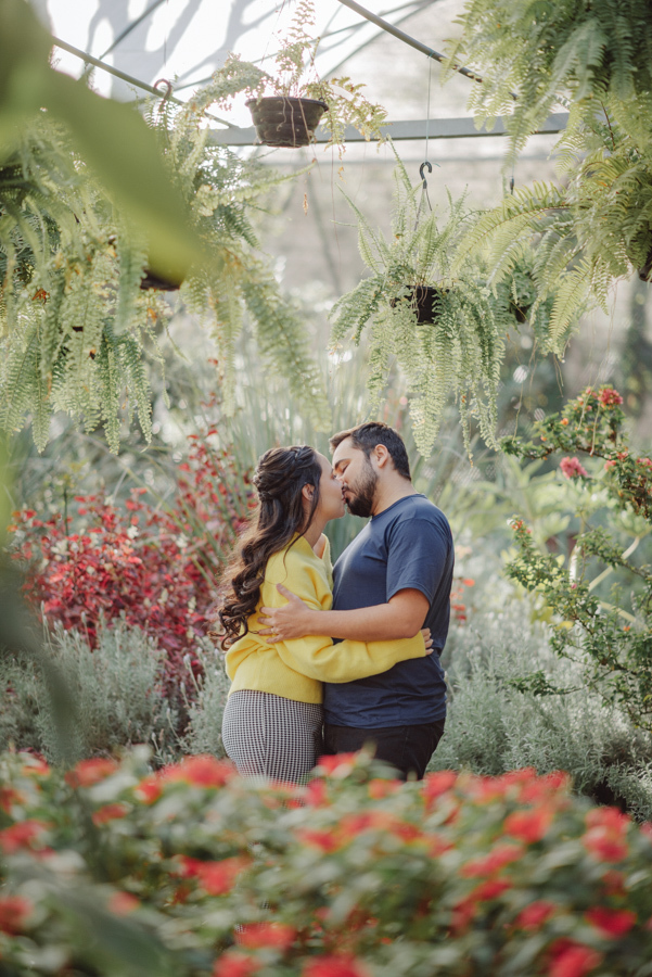 Abraço e cumplicidade: André e Nathália em ensaio pré-wedding em Campos do Jordão. Registro lifestyle aconchegante no sofá de crochê durante o outono na Serra da Mantiqueira. Fotógrafo de casamento capturando a essência e o carinho do casal.