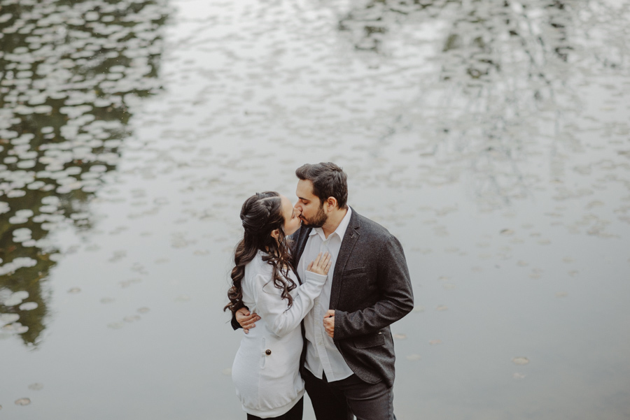 Beijo de André e Nathália visto de cima à beira do lago em Campos do Jordão. Ensaio pré-wedding na Serra da Mantiqueira capturando o romantismo e a paz do cenário natural. Fotógrafo de casamento com olhar artístico e lifestyle.