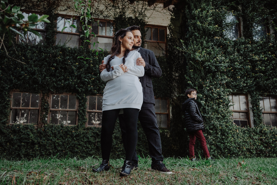 André e Nathália em ensaio pré-wedding lifestyle em Campos do Jordão. Registro autêntico em frente a fachada de hera na Serra da Mantiqueira, incluindo o filho no cenário. Fotógrafo de casamento especializado em capturar conexões e momentos reais.