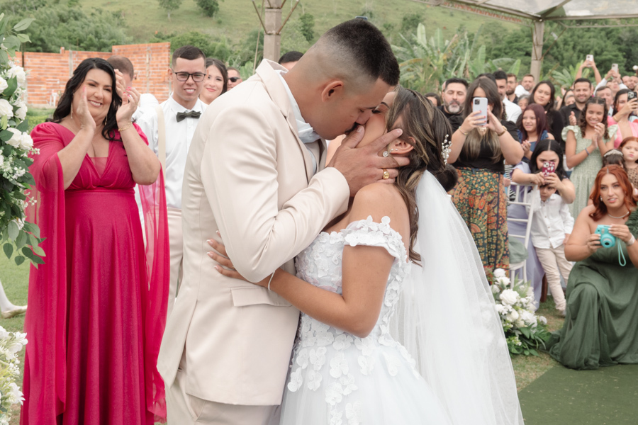Beijo apaixonado dos noivos Larissa e Ricardo no altar após o 