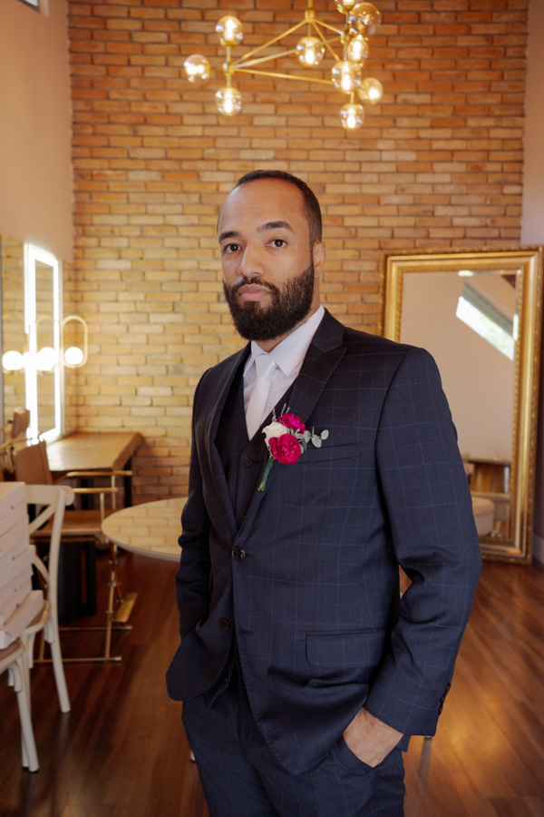 Retrato do noivo Matheus pronto para o casamento em Jacareí, vestindo terno azul marinho com flor de lapela rosa. Fotografia de making of no Boulevard, destacando a elegância masculina sob o olhar do fotógrafo Gilson Dias.