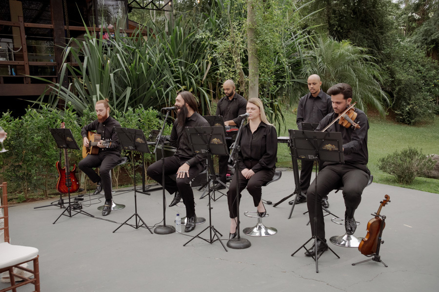 Banda musical ao vivo para cerimônia de casamento em Jacareí. Músicos com violino, violão e vozes se apresentam no Boulevard sob o olhar atento do fotógrafo Gilson Dias, criando a atmosfera perfeita para o dia de Claudia e Matheus.