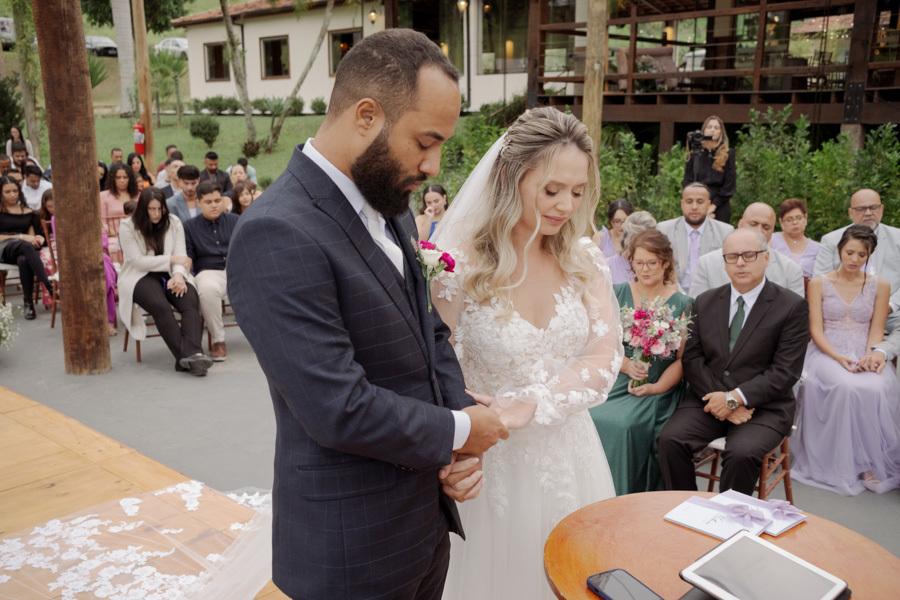 Noivo Matheus e noiva Claudia de cabeças baixas em momento de oração no altar do Boulevard Jacareí. Fotografia de casamento capturando a espiritualidade e emoção da cerimônia ao ar livre, registrada pelo fotógrafo Gilson Dias.
