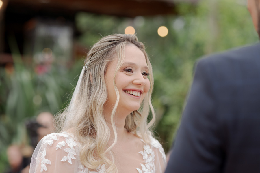 Close da noiva Claudia sorrindo emocionada para o noivo Matheus durante a troca de votos no Boulevard Jacareí. Fotografia de casamento capturando a felicidade e o brilho no olhar em cerimônia ao ar livre, registrada pelo fotógrafo Gilson Dias.