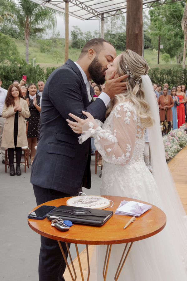 O primeiro beijo de Claudia e Matheus como casados no altar do Boulevard Jacareí. Fotografia de casamento emocionante capturando o romantismo e a celebração do casal ao ar livre, registrada pelo fotógrafo Gilson Dias.