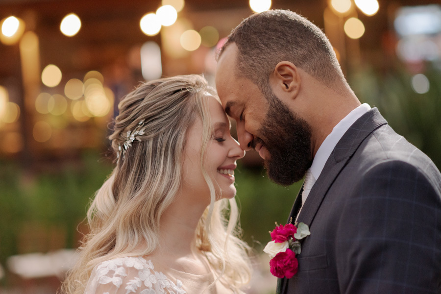 Close romântico de Claudia e Matheus com as testas encostadas e olhos fechados no Boulevard Jacareí. Fotografia de casamento capturando a serenidade e o amor do casal com luzes desfocadas ao fundo, registrada por Gilson Dias.
