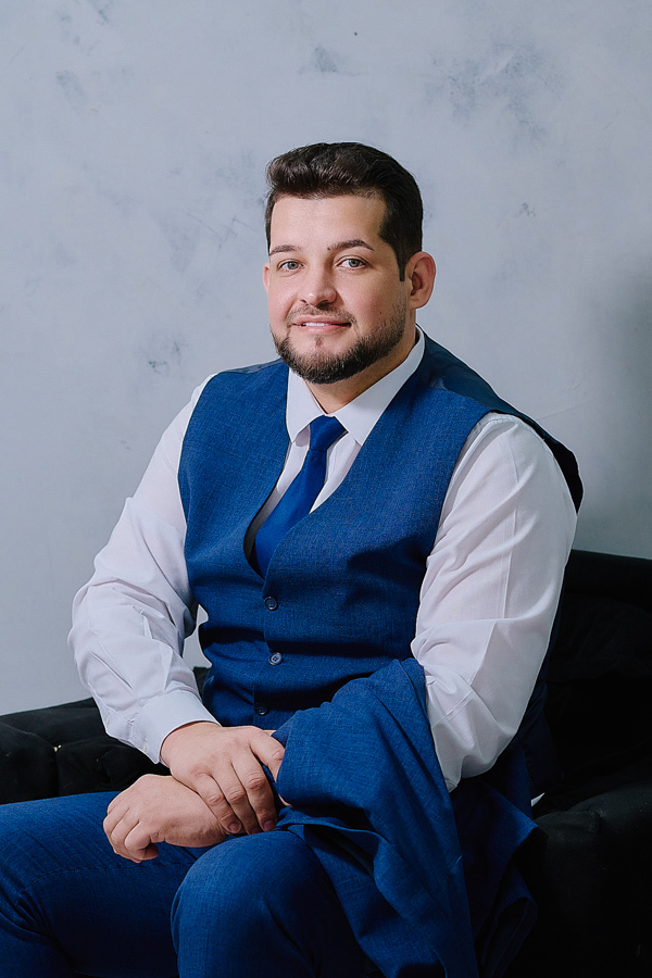 Retrato do noivo Caciano pronto para o casamento, vestindo terno azul e colete. Fotografia profissional em São José dos Campos destacando a elegância e a segurança do noivo para celebrar sua união com Paloma e suas filhas.