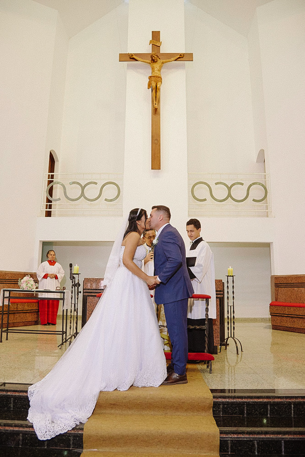 Primeiro beijo de casados de Marcela e Fernando no altar da Igreja Santa Maria em Jacareí. O casal sela a união diante da cruz em uma cena clássica.